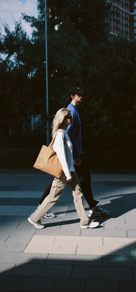 Two people walking through a city at dusk